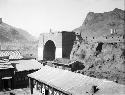 Large city gate with roof top in foreground