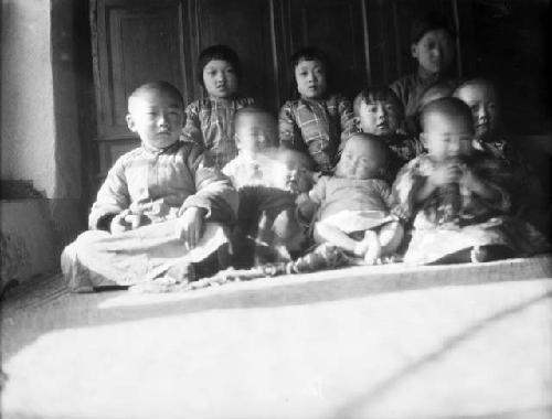 Portrait of eleven children sitting on the floor