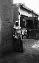 Woman outside inn, no location, cart in background