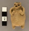 Rattle with suspension holes.  Effigy of woman holding breasts.