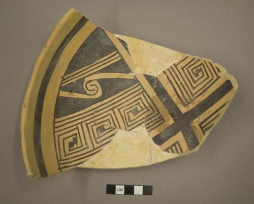 Fragments of black on yellow pottery bowl