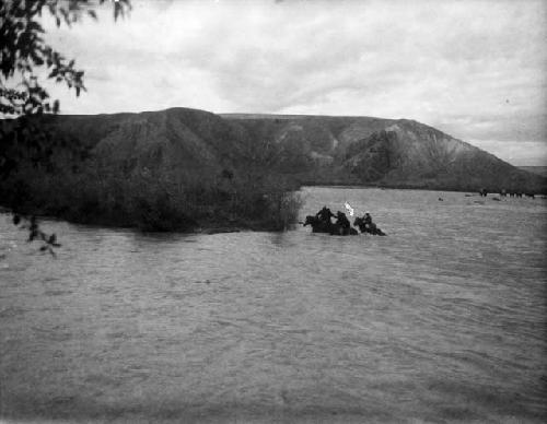 Horsemen fording river