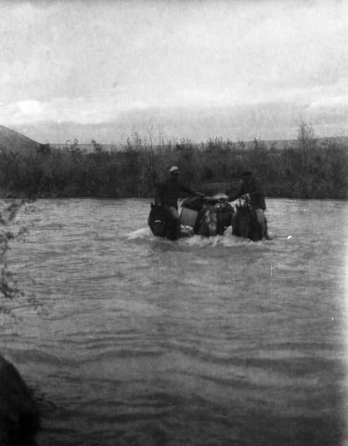 Horsemen fording river