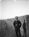 Paicheng-tze [Baicheng] policeman standing on a road, earthen wall behind