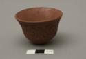 Miniature red pottery cup with incised scroll design