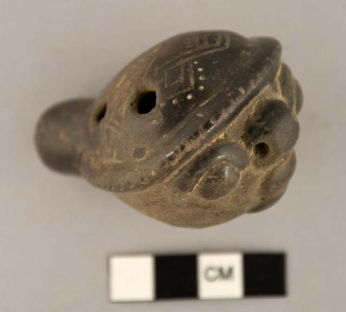 Four hole ocarina, whale shape; incised decoration, human face on side