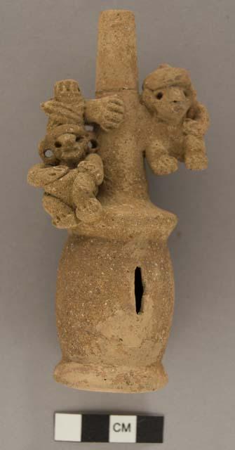 Unpainted clay rattle with 2 figures clinging to handle