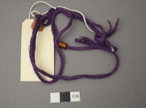 Purple string, with copper colored coil; identifies person who is baptized (tama