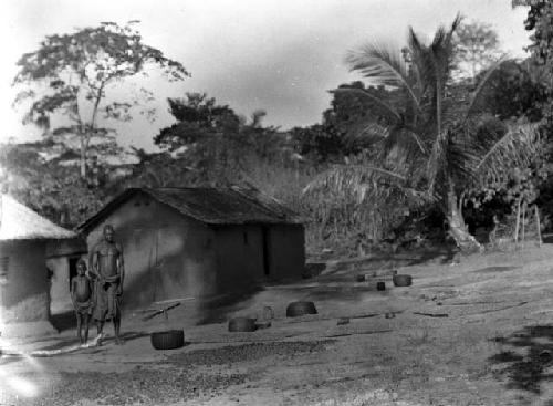 Man and child in front of Basa hut