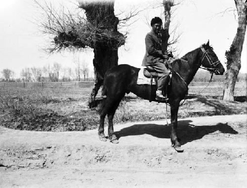 Russian stallion man mounted on horse outside of city