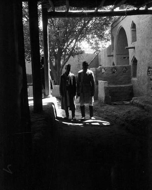 Old Toksun, two mullahs standing in mosque courtyard