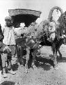 Man standing next to horse hitched up to cart