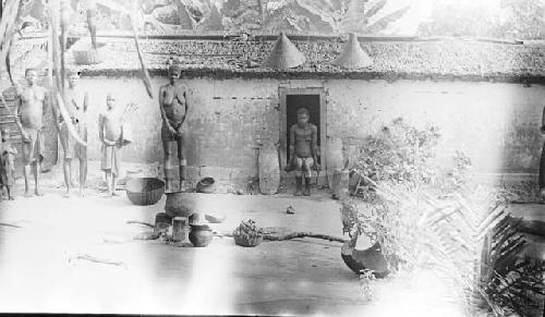 Homestead with larvae baskets kept on roof, family and housewares in front