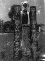 Man standing between two carved wooden parts of door frame