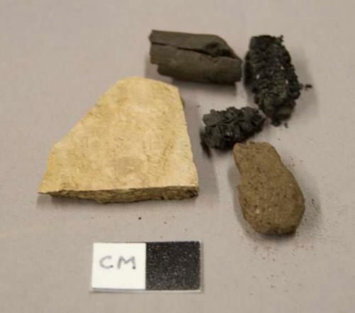 Earthenware body sherd, burnished, undecorated; burned corn cob fragments; burned wood fragments; clay fragment