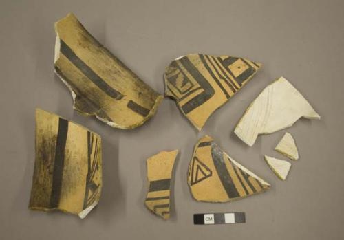 Fragments of black on yellow pottery bowl