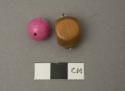 2 Beads; one circular, dyed pink; 1 wood, rectangular, with metal fastening