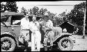 Three men in front of car