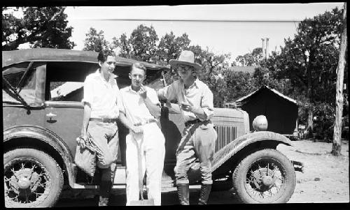 Three men in front of car