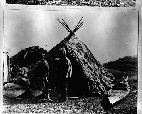 3 Eskimos in front of hut with kayak