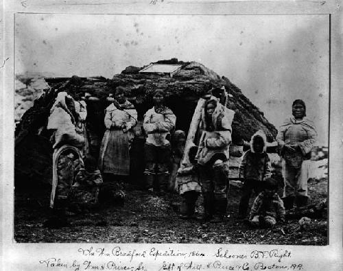 Eskimo women and children in front of hut