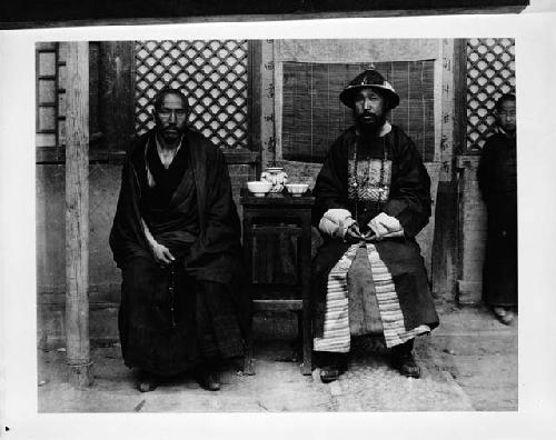 Two officials in their regalia with one of the llamas at Wan Yeh Fu