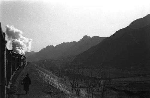 Mountain landscape with train at left foreground