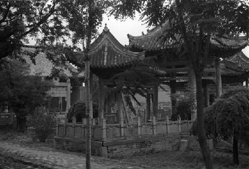 Courtyard with fence, trees and ornate gazebos or pavilions