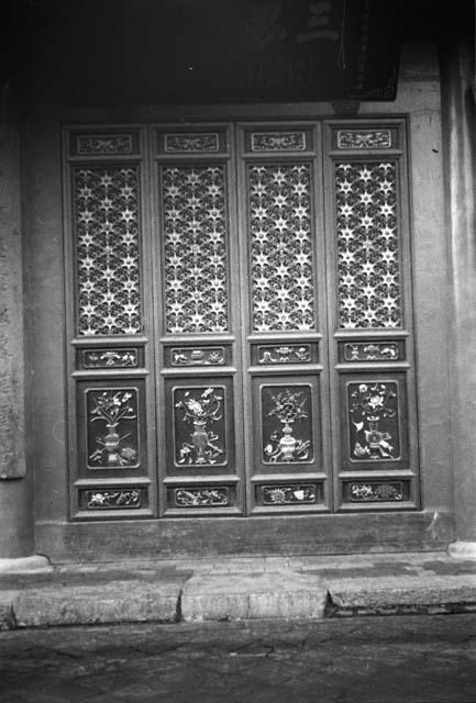 Ornate, carved and painted panel in stone wall