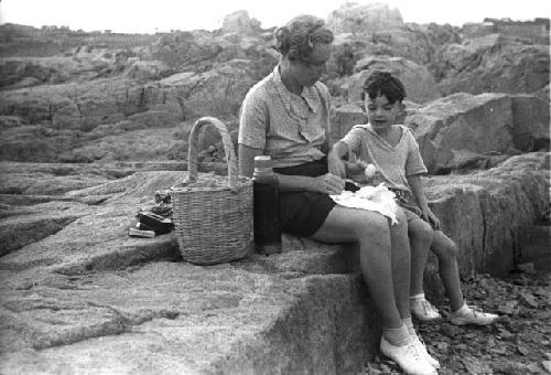 Eleanor and David Lattimore sitting on rocky ledge eating