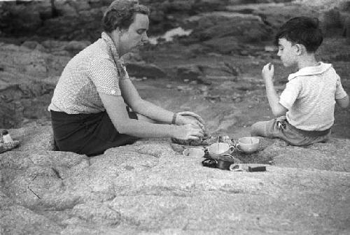 Eleanor and David Lattimore sitting on rocky ledge eating