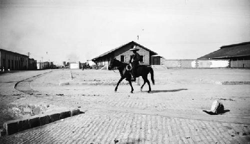 Man riding horse through street