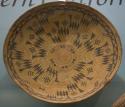 Basket tray, shallow bowl form. Coiled construction. Deep gold and blade decorat