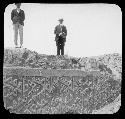 Men standing on top of archaeological structure