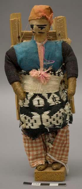 Doll, man with wooden pack on back, one of pair