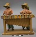 Dolls, 2 men playing marimba, affixed to stand