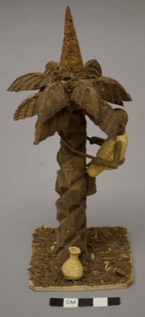 Thorn carving; palm fruit collector in tree