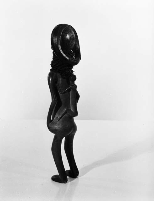 Female figure with child on back