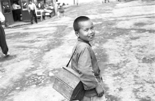 Boy walking carrying bag on shoulder