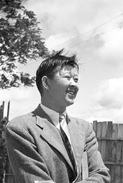 Portrait of man wearing suit, fence in background