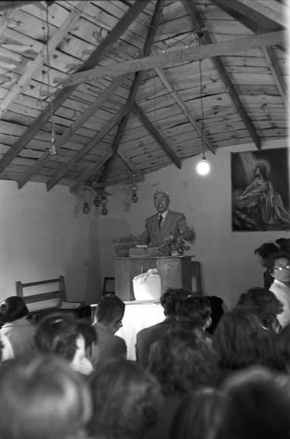 Minister at podium in church as people watch