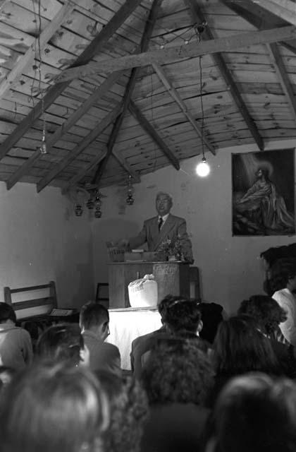 Minister at podium in church as people watch