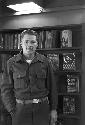 Portrait of man standing in front of book shelf