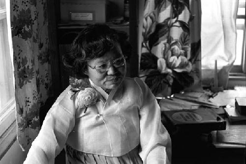 Portrait of woman standing by window looking down