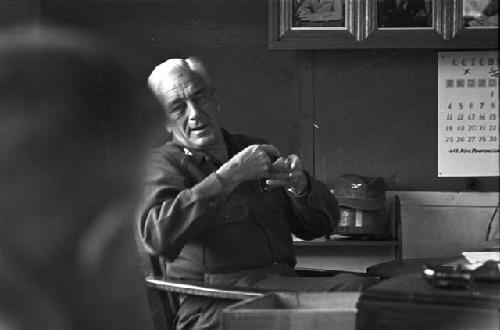 Portrait of man sitting in chair explaining to others