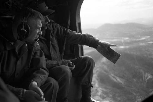 Soldiers in aircraft looking down at country