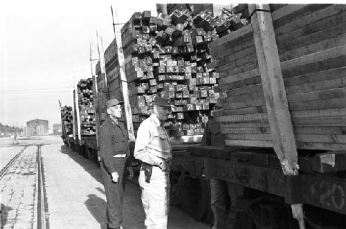 Soldiers stand watch as wood gets hauled