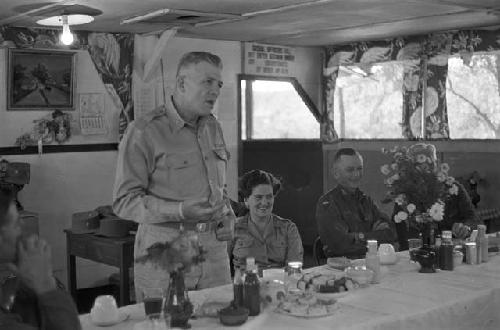 Soldier at head table addressing everyone inside banquet room