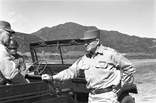 Soldier standing by jeep waiting