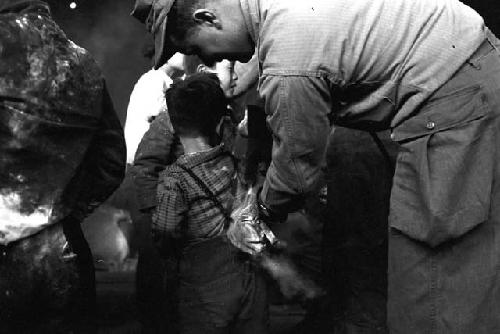 U.S. soldier spraying child with insecticide